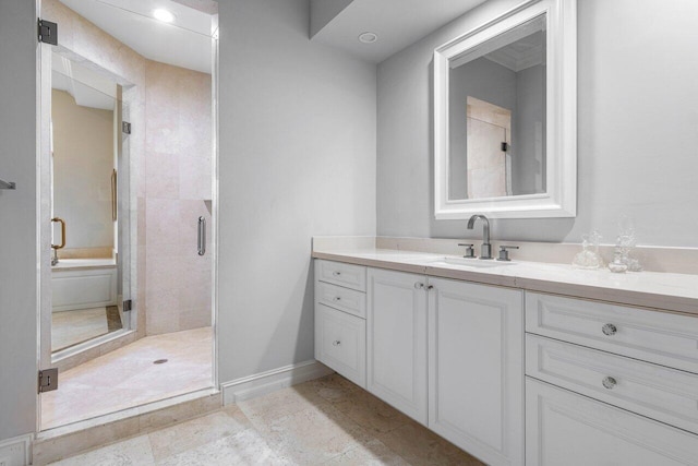 bathroom with baseboards, a shower stall, and vanity