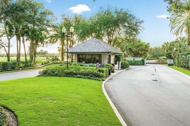 exterior space featuring curbs, a gated entry, and street lights