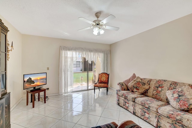 living room with light tile patterned flooring, a ceiling fan, and baseboards