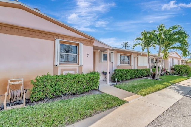 view of front of property with a front yard and stucco siding