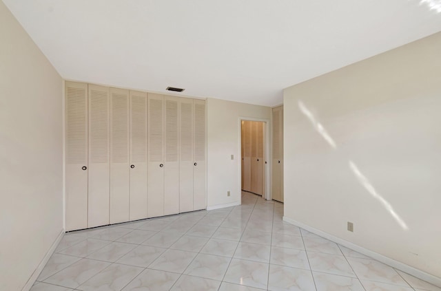 unfurnished bedroom with a closet, visible vents, and baseboards