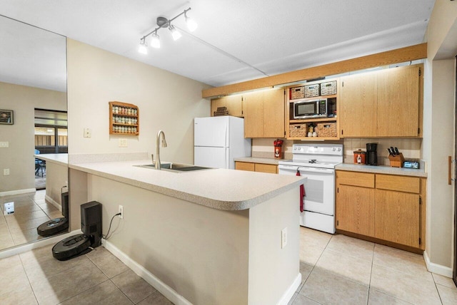 kitchen featuring light countertops, light tile patterned floors, a sink, white appliances, and a peninsula