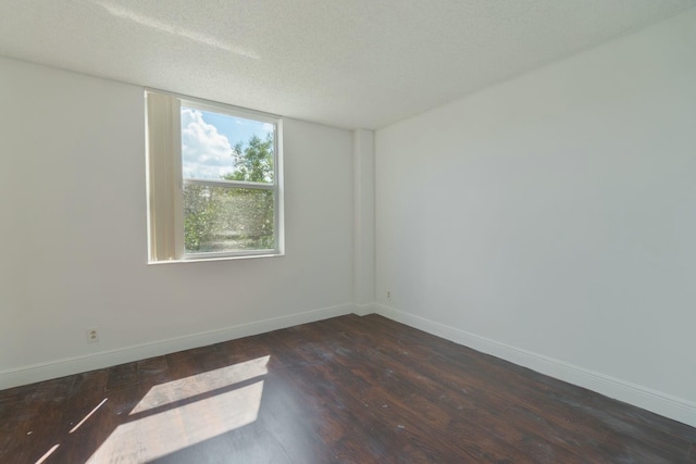 unfurnished room featuring a textured ceiling, baseboards, and dark wood-style flooring