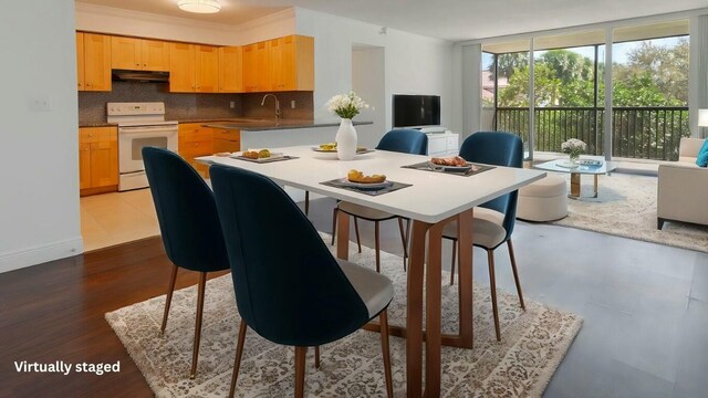 kitchen featuring white electric stove, under cabinet range hood, open floor plan, decorative backsplash, and dark countertops