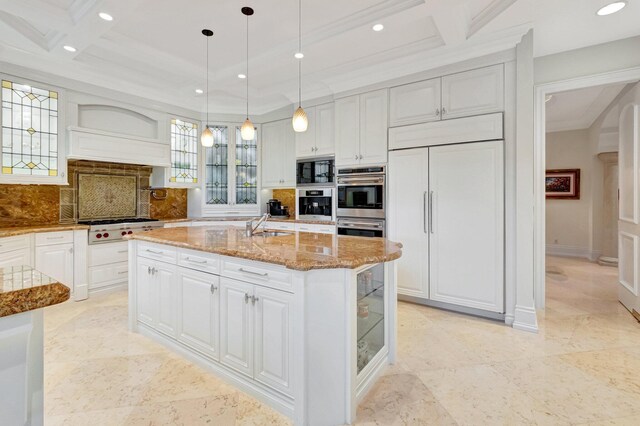 kitchen with built in appliances, white cabinets, glass insert cabinets, and light stone countertops