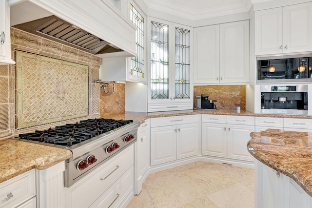 kitchen with white cabinets, ornamental molding, premium range hood, and stainless steel appliances