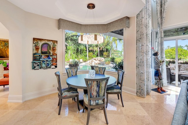 dining area with a raised ceiling and baseboards