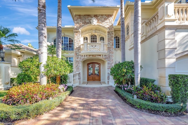 entrance to property featuring stone siding and french doors