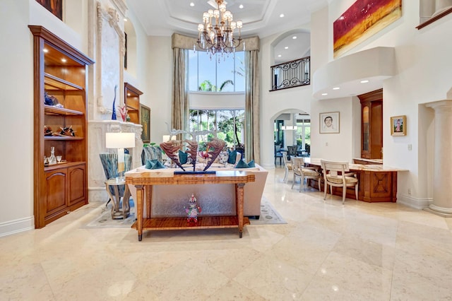 interior space with baseboards, an inviting chandelier, a tray ceiling, arched walkways, and ornamental molding