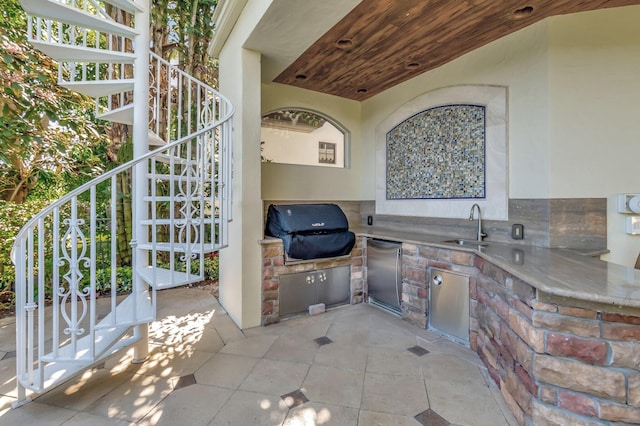 view of patio / terrace with a sink, area for grilling, a grill, and stairs