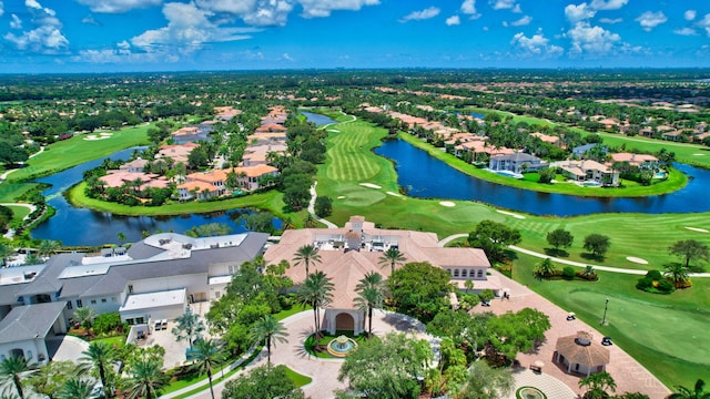 drone / aerial view with a residential view, golf course view, and a water view