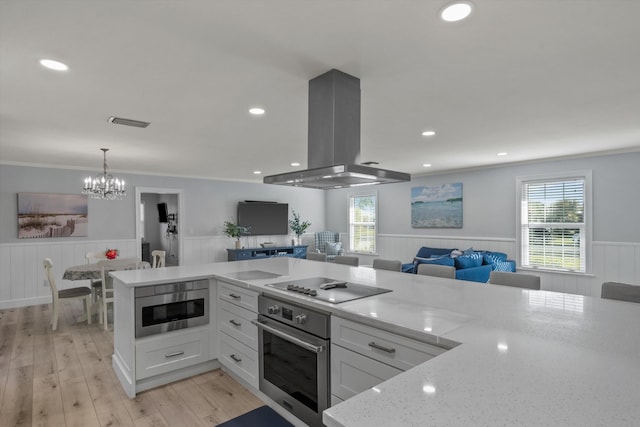 kitchen featuring island exhaust hood, black electric stovetop, open floor plan, built in microwave, and oven