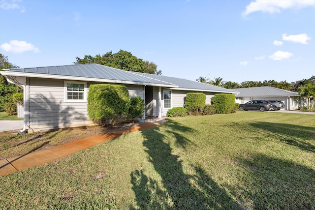 ranch-style house featuring metal roof and a front lawn