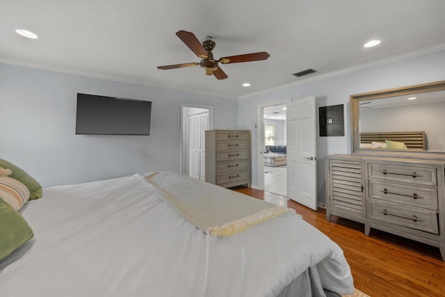 bedroom featuring crown molding, wood finished floors, and recessed lighting