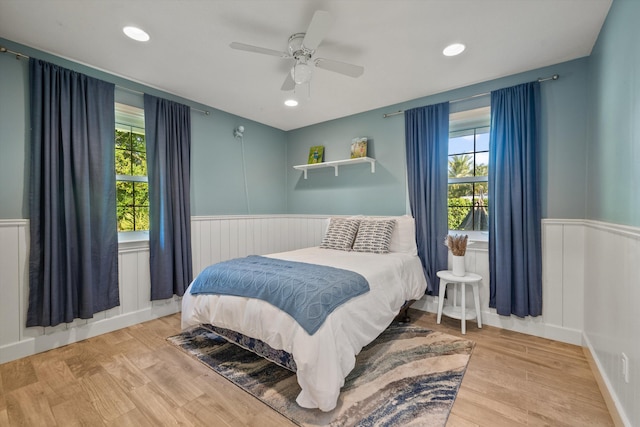 bedroom with recessed lighting, ceiling fan, wood finished floors, and wainscoting