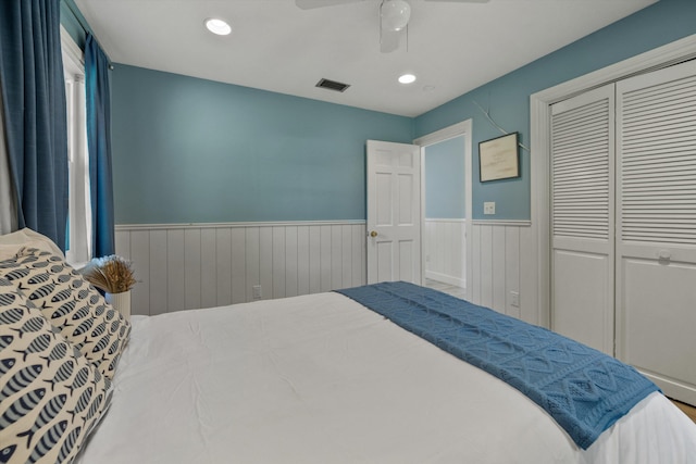 bedroom with recessed lighting, a closet, visible vents, a ceiling fan, and wainscoting