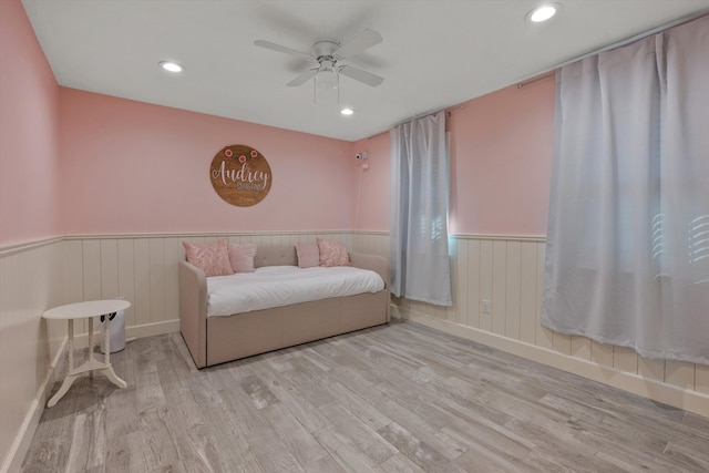 unfurnished bedroom featuring a ceiling fan, recessed lighting, a wainscoted wall, and wood finished floors