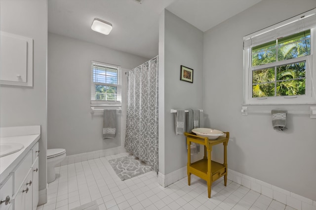 full bathroom featuring toilet, tile patterned flooring, baseboards, and vanity