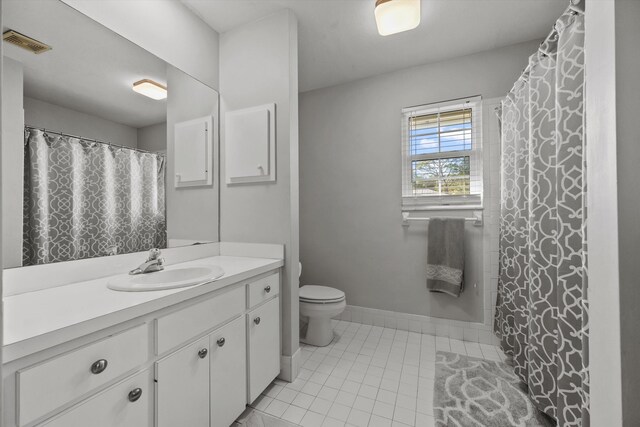 bathroom with toilet, vanity, baseboards, visible vents, and tile patterned floors