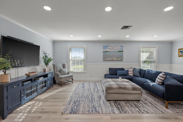 living room featuring a wainscoted wall, plenty of natural light, and visible vents