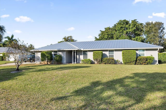 ranch-style home featuring a front yard and metal roof