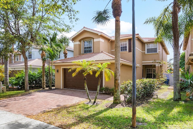 mediterranean / spanish house with a tiled roof, decorative driveway, and stucco siding