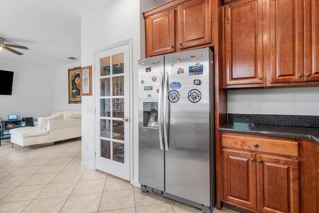 kitchen with brown cabinets, light tile patterned flooring, open floor plan, and stainless steel fridge with ice dispenser