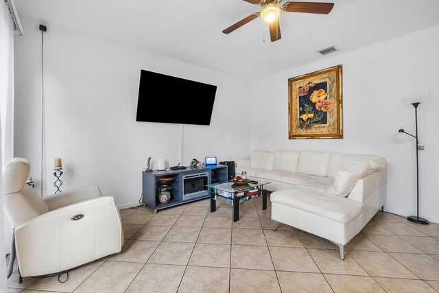 living area featuring light tile patterned floors, ceiling fan, and visible vents