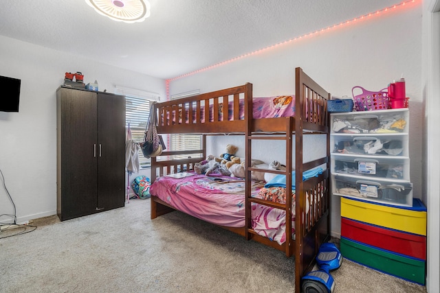 carpeted bedroom featuring baseboards and a textured ceiling