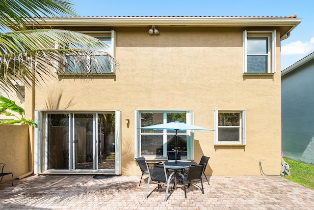 back of property featuring a patio area and stucco siding