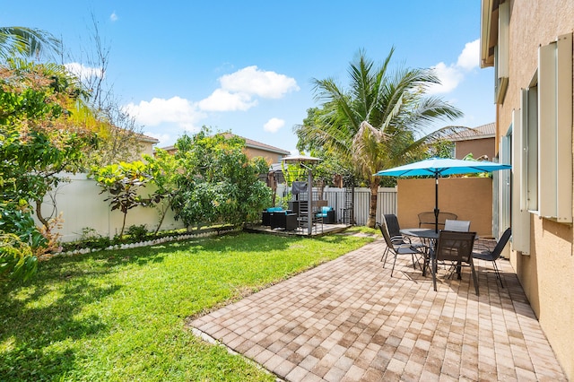 view of yard featuring outdoor dining space, a fenced backyard, and a patio