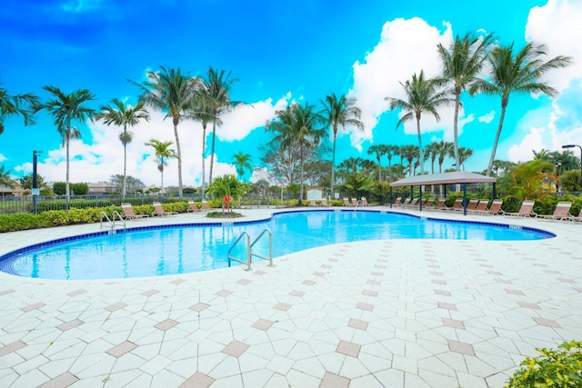 community pool featuring fence and a patio