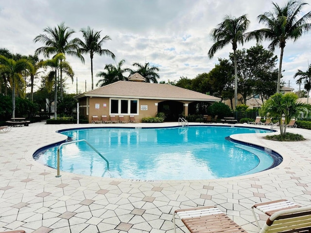 pool with a patio area and fence