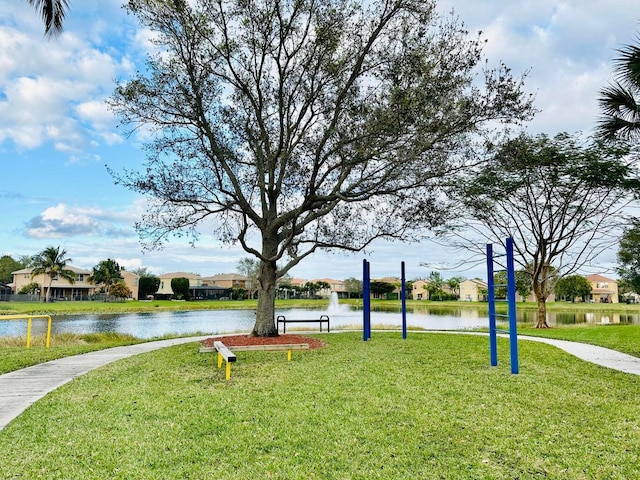 view of home's community with a water view and a lawn