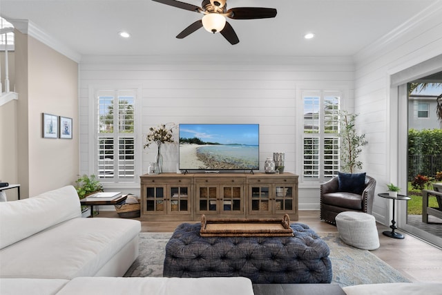 living room featuring a wealth of natural light, crown molding, and wood finished floors