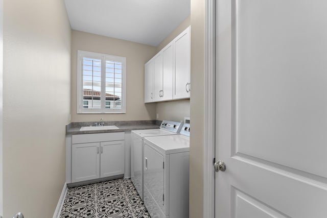 clothes washing area featuring light tile patterned floors, washing machine and dryer, a sink, baseboards, and cabinet space