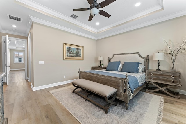 bedroom with light wood finished floors, baseboards, visible vents, and crown molding