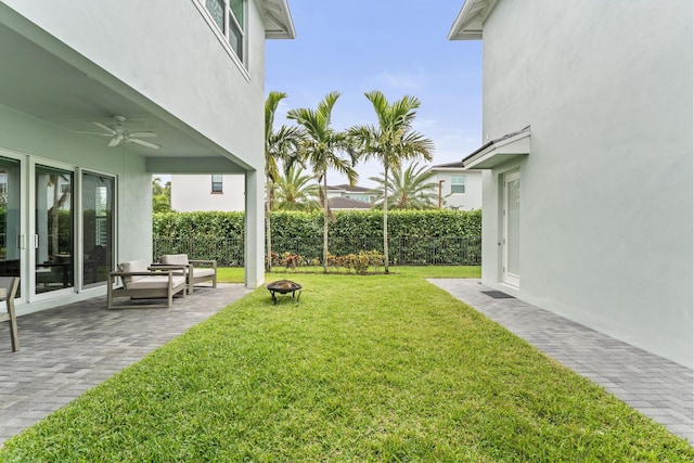 view of yard with an outdoor fire pit, a patio area, fence, and ceiling fan