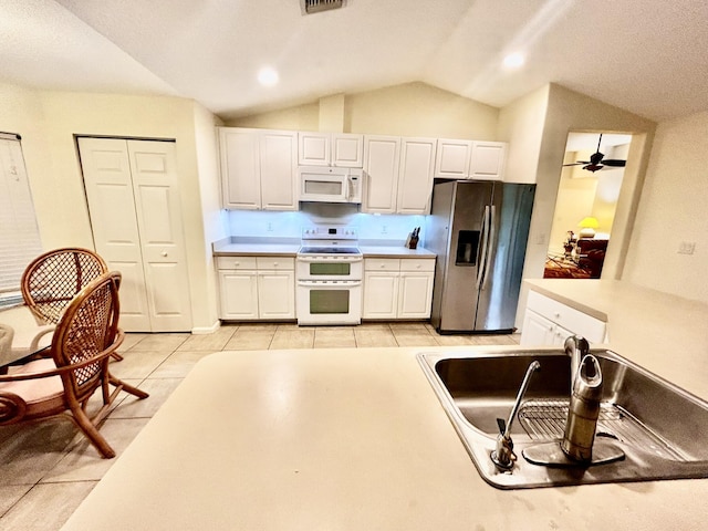 kitchen featuring white appliances, a sink, and white cabinets