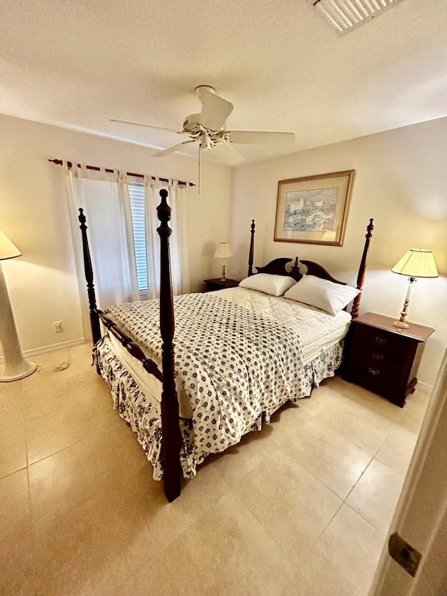 tiled bedroom with baseboards, visible vents, and a ceiling fan