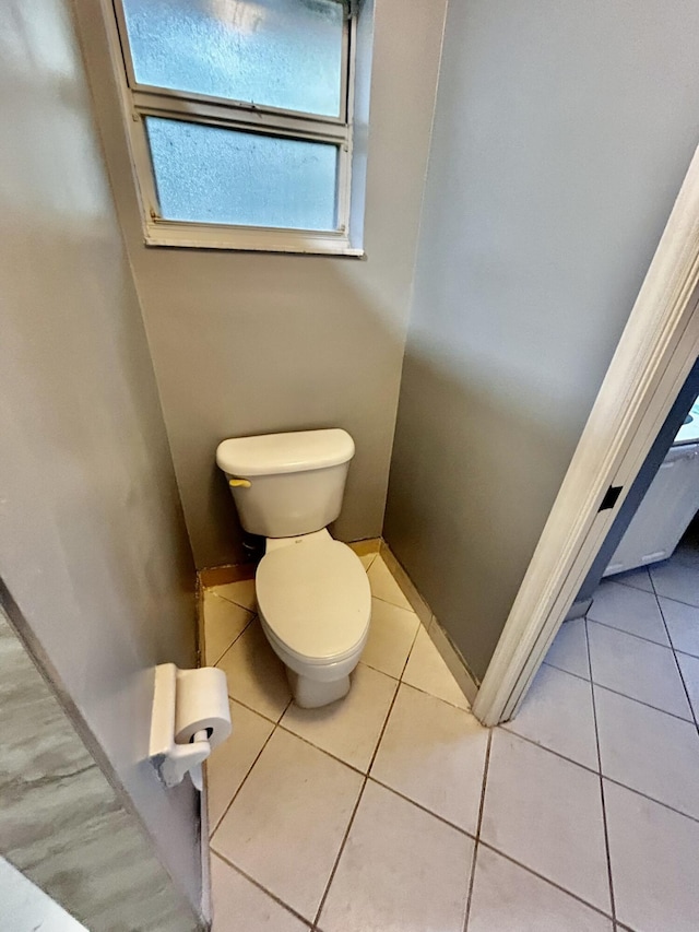 bathroom with toilet, tile patterned flooring, and baseboards