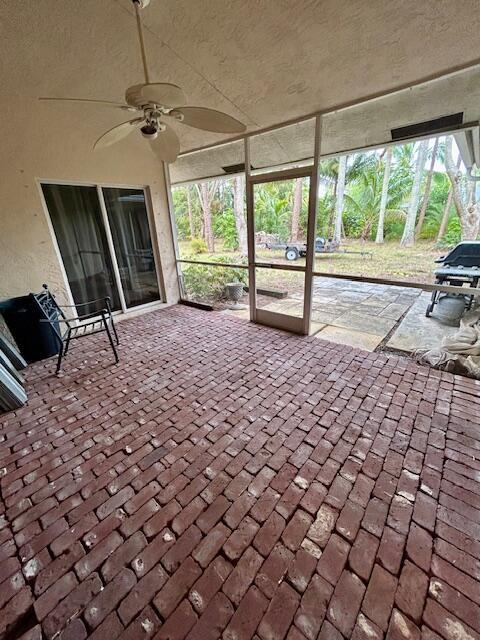 unfurnished sunroom with a healthy amount of sunlight and a ceiling fan