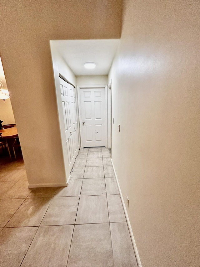 hall with light tile patterned floors and baseboards