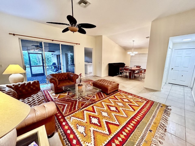 tiled living room featuring visible vents, vaulted ceiling, and ceiling fan with notable chandelier