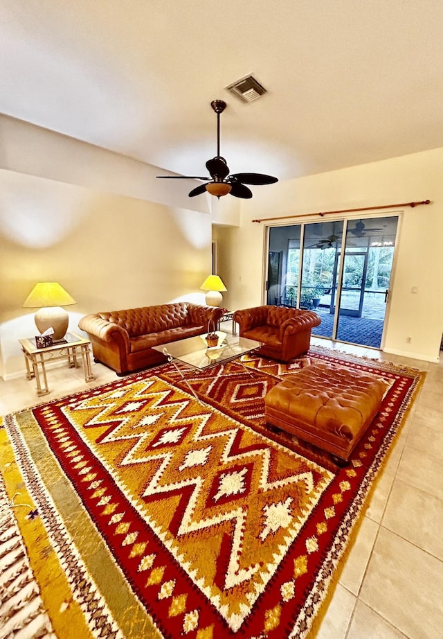 living area featuring ceiling fan, visible vents, baseboards, and tile patterned floors