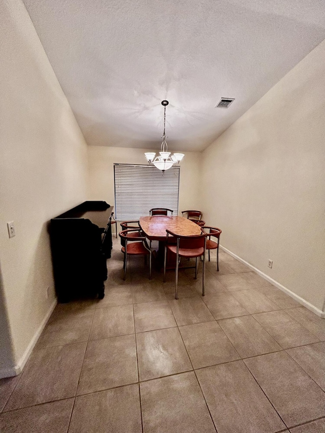 dining space featuring visible vents, a notable chandelier, a textured ceiling, and baseboards