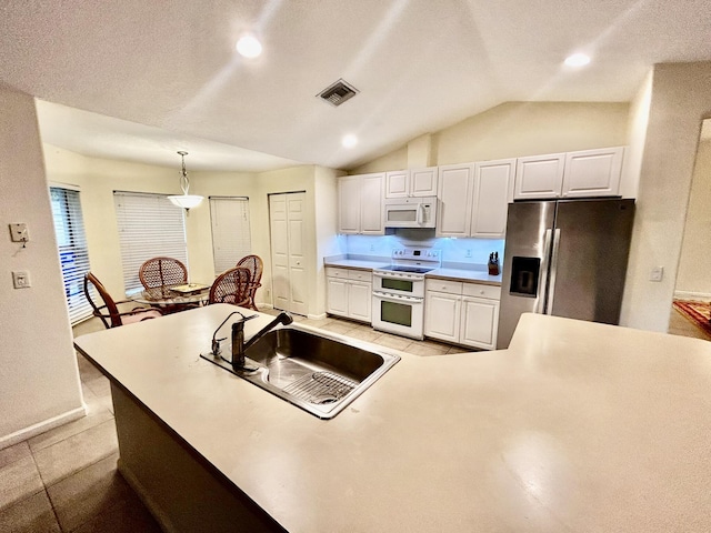 kitchen with white appliances, visible vents, lofted ceiling, white cabinetry, and a sink