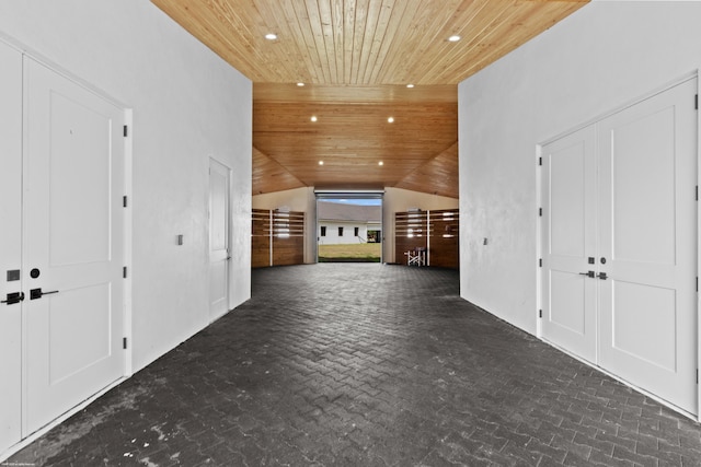 unfurnished living room with lofted ceiling, brick floor, wood ceiling, and recessed lighting