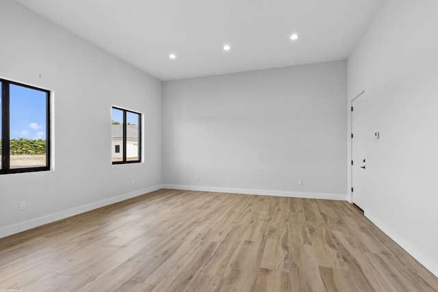 unfurnished room with baseboards, light wood-style flooring, and recessed lighting