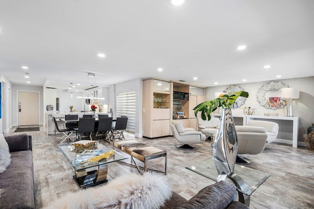 living area with baseboards, light wood-style floors, and recessed lighting